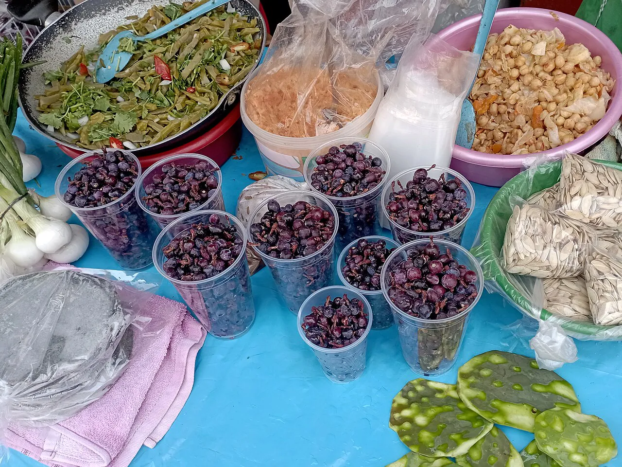 Small dark fruits displayed in containers.